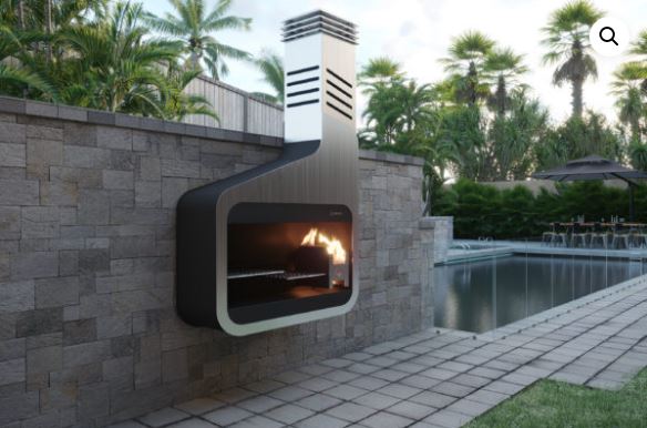 Modi braai, a wall-mounted unit in black and stainless steel with a curved flue, alight on a stone wall beside a pool